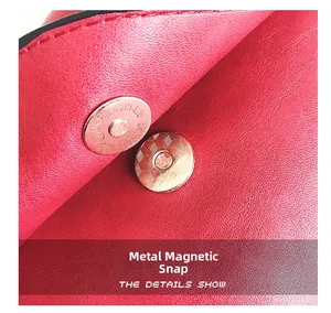 Detailed macro view of the magnetic snap closure on a red textured leather shoulder bag