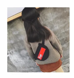 Gros plan d'un sac de poitrine noir en toile pour filles avec logo rouge sur un pull