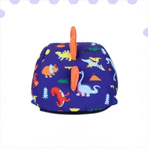 Detail view of navy blue kids dinosaur backpack with cartoon prints and 3D orange fins