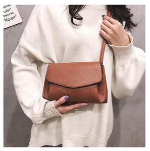 Close-up of caramel brown retro leather crossbody bag with pleated side details on model