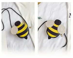 Détail du joli sac bandoulière en cuir forme abeille avec rayures jaunes et noires