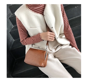 Brown vintage kiss-lock crossbody bag in smooth leather shown worn with a casual outfit