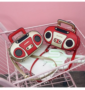 Dettaglio di borse a tracolla vintage a forma di radio in un cesto rosa con spalline