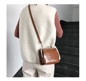 Detailed back view of vintage brown leather crossbody bag with metal frame clasp closure