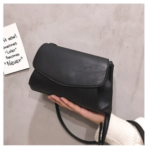 Detail view of the black soft leather shoulder bag with a sleek flap closure design