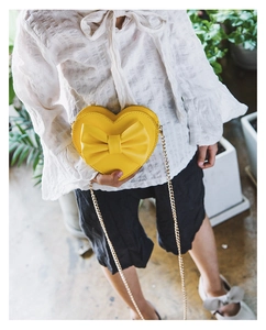 Kids heart-shaped crossbody bag in yellow PU leather with a large bow and gold chain
