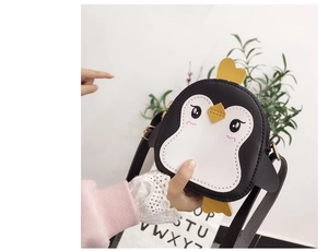 Detail of cute cartoon penguin crossbody bag for kids made of white and black PU leather