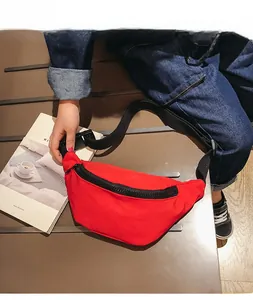 Close-up of red nylon kid's waist bag with adjustable strap worn by a young model