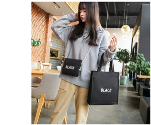 Détail d'un ensemble de sacs en toile noire avec lettrage BLACK blanc imprimé