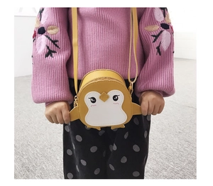 Close-up of cute yellow penguin crossbody bag with embroidery on child model