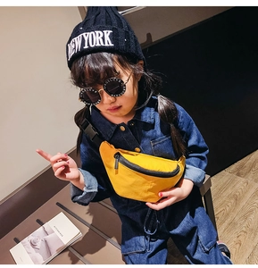Detail view of bright yellow nylon kids waist bag with adjustable strap and black zipper