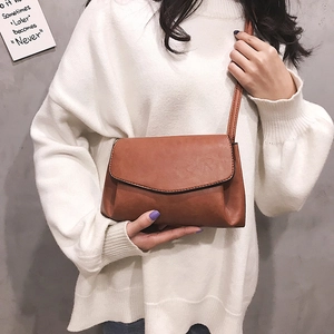 Minimalist tan leather envelope crossbody bag for women with a stylish flap and shoulder strap