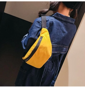 Close-up of yellow nylon waist bag for kids with black adjustable strap and zipper