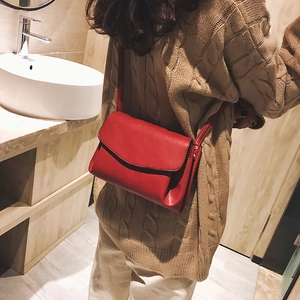 Red minimalist faux leather crossbody bag worn by model in a stylish daily setting