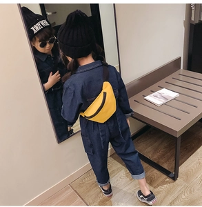 Kid's street style outfit featuring a yellow canvas waist bag and navy blue denim jumpsuit