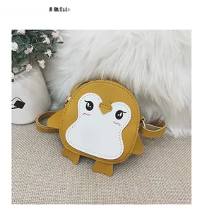 Detail of yellow penguin cartoon shoulder bag for children with embroidered eye features