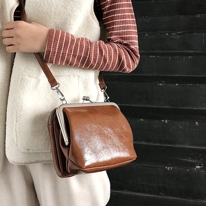 Retro brown leather kiss-lock crossbody bag with silver frame and slim shoulder strap