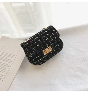 Detail of black tweed crossbody bag with multi-color weave and gold twist lock