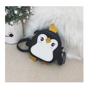 Detailed view of the cute penguin cartoon shoulder bag on a cozy woven surface