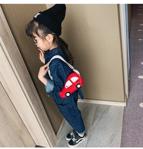 Detailed view of car-shaped kids crossbody bag with familiar branding and tassels