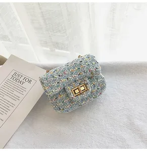 Close-up of a blue tweed crossbody bag for girls with a gold twist lock and woven texture
