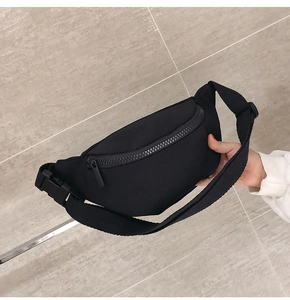 Detail of children's black nylon waist bag with adjustable strap and plastic buckle closure