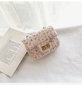 Close-up of pink tweed girl's crossbody bag with elegant gold metal turn-lock clasp