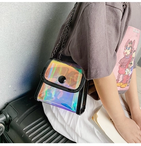 Détail d'un mini sac bandoulière laser PVC irisé avec chaîne noire porté par un mannequin