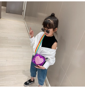 Toddler model wearing a holographic purple heart purse with a rainbow woven strap
