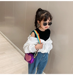 Girl wearing purple heart crossbody bag with vibrant rainbow wide shoulder strap