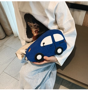 Detail of blue car-shaped corduroy shoulder bag with familiar embroidery and fringe