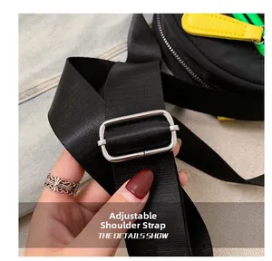Detail of adjustable woven nylon shoulder strap with silver metal buckle on a black crossbody bag