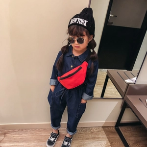 Kids cute red waist bag styled with denim jumpsuit and black knit beanie for street fashion
