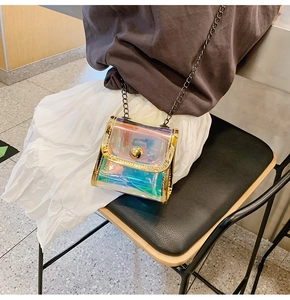 Détail d'un mini sac holographique laser avec verrou métallique doré et bandoulière chaîne
