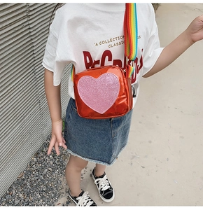 Detail of kids orange mirror crossbody bag with pink sequin heart and rainbow strap