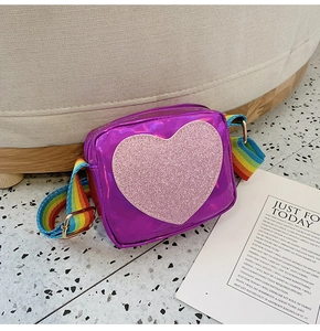 Close-up of shiny purple heart bag with pink sequins and a colorful rainbow strap