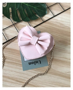 Pink heart-shaped crossbody bag for girls featuring a large bow and gold chain strap