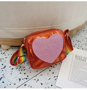 Detail of laser textured orange mini bag with glitter heart and rainbow strap