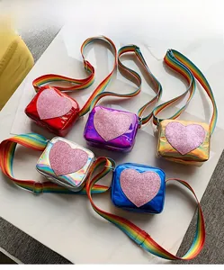 Detail view of colorful glossy kids crossbody bags with glitter heart and rainbow straps