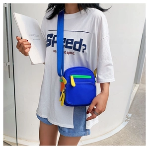 Close-up of royal blue nylon crossbody bag featuring vibrant color-blocked zipper details