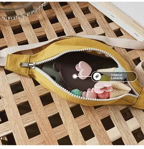Close-up of yellow canvas belt bag interior showing storage capacity and white zipper