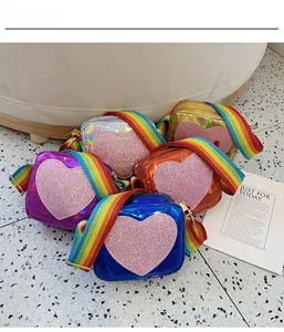 Macro shot of colorful laser patent leather bags with pink glitter hearts and rainbow straps