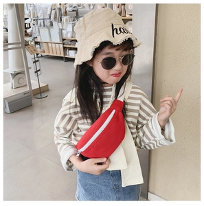 Detail of a red canvas crossbody waist bag for girls with a white zipper and sleek design