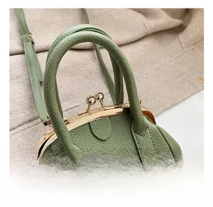 Detail of olive green lychee pattern leather handbag with premium gold metal clasp
