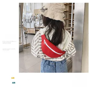 Back view of a child wearing a red canvas crossbody chest bag with a striped shirt