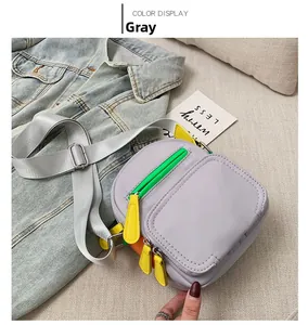 Detail of grey crossbody bag with vibrant neon green and yellow zipper accents