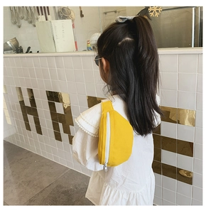 Detailed view of yellow canvas waist bag for girls styled as a crossbody chest pack