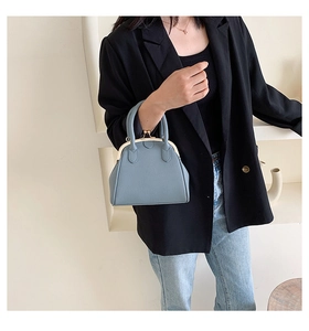 Close-up of blue lychee texture leather handbag with doctor bag metal frame closure