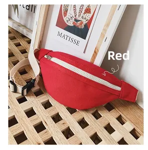 Detail of red canvas kids waist bag with cream zipper on a light wooden surface