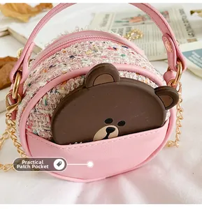 Détail du mini sac en tweed rose avec accessoire ours et bandoulière chaîne dorée